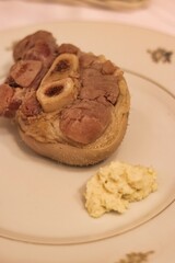 Close-up of cooked pork shank on a plate on the table