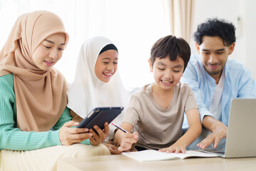 Asian muslim family relaxing in living room together.