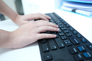An employee is typing on a computer keyboard.