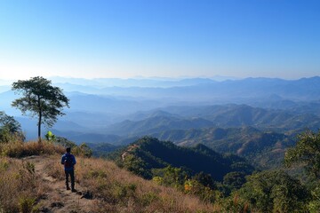 A man standing on top of the mountain, overlooking distant mountains and sky at sunrise with copy space text. Horizontal shot, wide-angle lens, natural lighting, best quality, realistic photo,