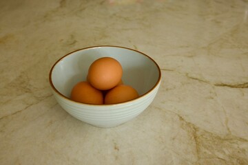 brown eggs in a ceramic bowl