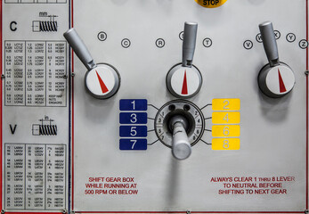 A control panel with various levers, dials, and detailed settings for gear shifting and threading.