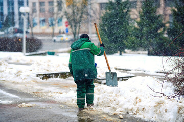 Worker remove snow from sidewalk during blizzard, clean footpath. Utility worker shoveling snow on city street. Man clearing snowy walkway with shovel. Snow removal work, ensuring pedestrian safety © Tricky Shark