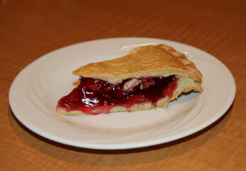 Slice of Traditional American Dessert  Cherry Pie on white plate