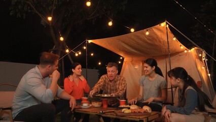 Family gather for holiday celebration in garden. Family member gather have dinner. Outdoor camping activity to relax with food and spend time with younger generation cross generation gap. Divergence.