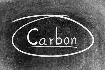 Fototapeta premium White chalk hand writing in word carbon and circle shape on blackboard background