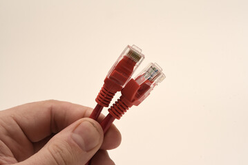 Red internet cable in hand. The RJ-45 connector.
