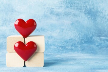 Fototapeta premium Two Red Hearts on Wooden Blocks Against a Soft Blue Background
