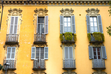 Facade of old yellow building with shuttered windows