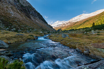 Alpine river with snowy mountains and forest in the Krimmler Achental, Austria