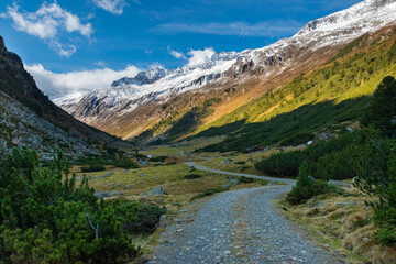 Naklejka premium Mountain road through alpine valley with snowy mountains in the Krimmler Achental, Austria
