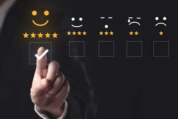 Hand touching and doing mark to select smiley face icon for evaluate product and service, customer...
