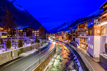 Nighttime View of Zermatt, a Picturesque Swiss Village by the River With Illuminated Buildings and...