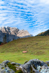 Colorful autumn landscape at Großer Ahornboden in the Karwendel Mountains, Austria – forest with fall foliage, rocky peaks and dramatic sky
