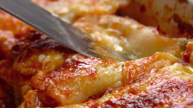 A piece of cooked lasagna rises up with melted cheese. Top view. High quality 4k footage