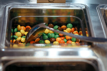 chocolate candy in a stainless container is used for topping