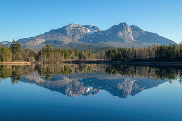 Majestic mountain range reflecting in a crystal-clear lake, a serene natural landscape of the Canadian national park system. The beautiful blue sky, golden hour lighting, and pine trees