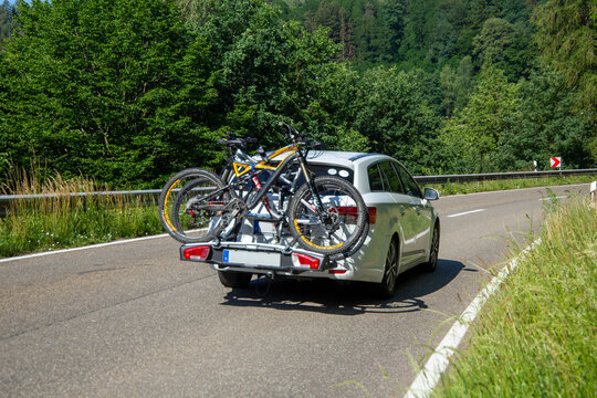 Wei&szlig;er PKW mit Fahrrad-Hecktr&auml;ger von Thule auf einer Landstra&szlig;e im Dahner Felsenland (Deutschland)