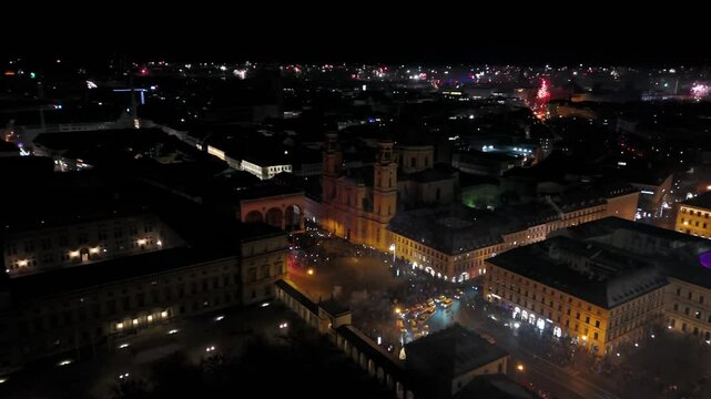 Aerial view at midnight of fireworks rockets and firecrackers in downtown Munich, Germany at Odeonplatz. Feldherrnhalle and Theatinerkirche in salute. Silvester Feuerwerk uber Munchen Luftaufnahme. 