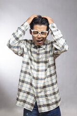 Fototapeta premium A man wearing white glasses and a checked shirt held his head in stress.