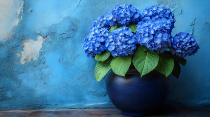 A blue vase with blue flowers in it sits on a blue wall