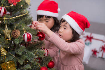 女の子たちが一緒に楽しむクリスマスツリーのデコレーション