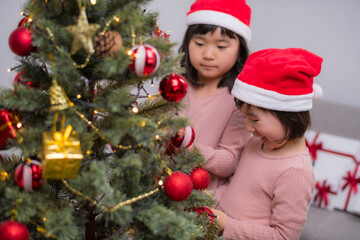 女の子たちが一緒に楽しむクリスマスツリーのデコレーション