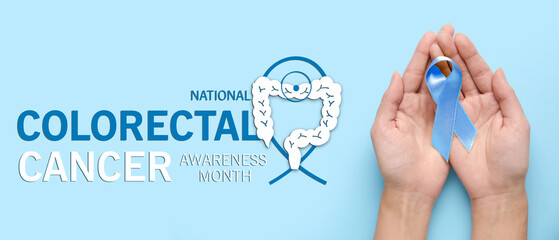 Female hands with golden awareness ribbon on blue background. International Childhood Cancer Day