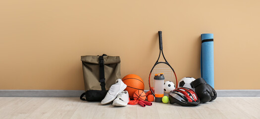 Set of sport equipment on floor near color wall