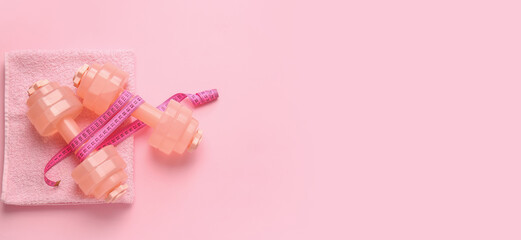 Dumbbells, towel and measuring tape on color background