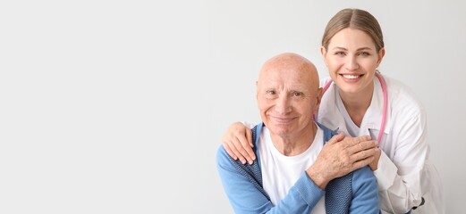 Elderly man with doctor on light background with space for text