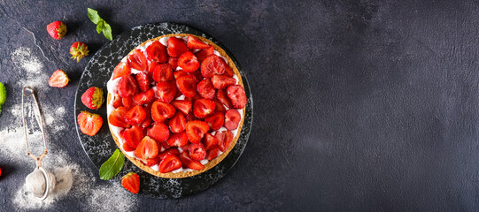 Board with tasty strawberry pie on dark background