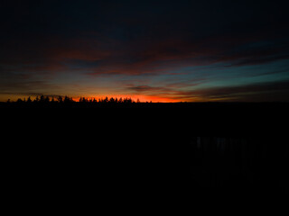 Magische Abendstille: Waldsilhouette im leuchtenden Sonnenuntergang