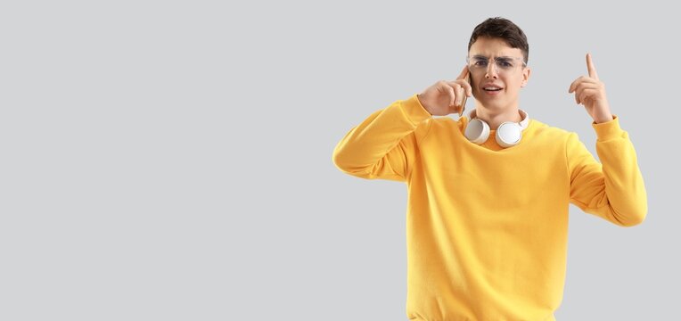 Angry young man talking by mobile phone on light background with space for text - Powered by Adobe