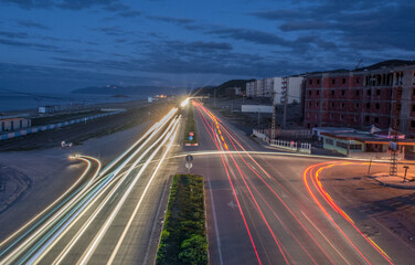 Red cars lights at night. long exposure, Wave motion speed red and blue lighting background, Movement of lights with curve in showing road or highway, car light trails on scenic road in jijel Algeria.
