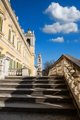The grand staircase of Colorno's royal palace in Parma, showcasing stunning Baroque architecture and vibrant sunlight