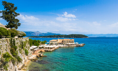 Faliraki on Corfu with public baths and beach with Vido islet in the background on Corfu island, Greece