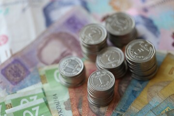 Few stacks of ukrainian money coins lies on old hryvnia banknotes