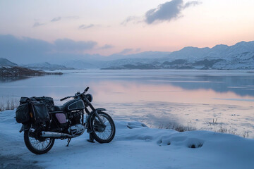 Obraz premium motorcycle parked beside a frozen lake, surrounded by snow and mountains on backdrop, creating a peaceful and reflective winter landscape at sunrise or sunset