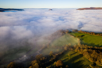Drone shot of low lying fog covering rural farmland and fields (Brecon Beacons)
