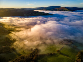 Drone view of fog and farmland in late afternoon sunlight