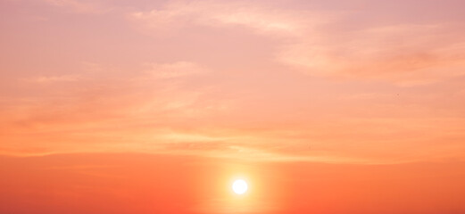 Sunset sky summer background with beautiful natural yellow sunlight and cloud on panoramic orange sunrise sky in golden hour time