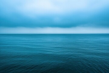 Obraz premium Serene ocean view under a cloudy sky, evoking tranquility and calmness.
