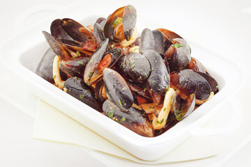 Baked moules with tomatoes, hot sauce, butter and parsley, Mediterranean cuisine, European food