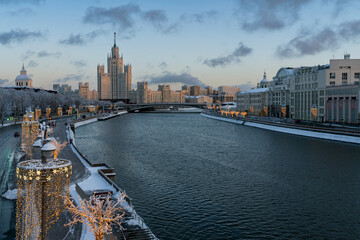 View of the Moskvoretskaya embankment of the Moskva River and the Stalin high-rise apartment building on Kotelnicheskaya Embankment with New Year decorations, Moscow, Russia