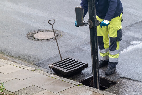 Arbeiter reinigt die Stra&szlig;enkanalisation