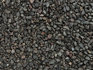 Black pebble stones or charcoal pebbles as decorative material on landscape garden or park, pebbles...