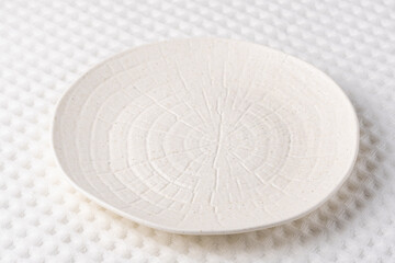 Simple white ceramic plate with textured surface designed for modern dining experiences in contemporary settings