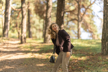 Portrait of a beautiful blonde young girl in a summer city park.