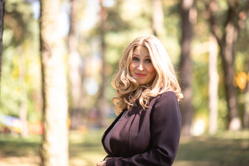 Obraz premium Portrait of a beautiful blonde young girl in a summer city park.